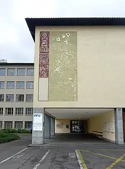 Max Kämpf (1912–1982) Maler und Zeichner. Sgraffito, Das Meer. 1948–1950, an der Fassade des Wirtschaftsgymnasium-Schule in Basel. Auf dem Bildnis war zusätzlich ein Schmied (Allegorie auf das Handwerk) dargestellt (angeblich Stalin gleichend), dieser wurde jedoch nach der sogenannten «Schnauzaffäre» und nach der Weigerung einer Überarbeitung des entsprechenden Details über Nacht weggemeisselt.