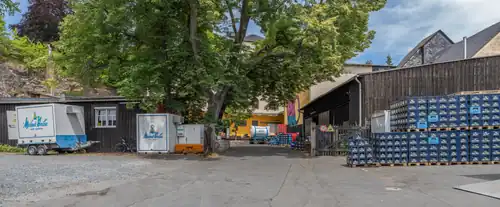 Das Foto zeigt den Standort des Meinel-Bräu. Rechts sind gestapelte Bierkästen