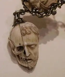 Memento Mori an einem Rosenkranz aus dem frühen 16.&nbsp;Jahrhundert, Leben (Antlitz) und Tod (Schädel), gespalten an einem Kopf, als Amulett.