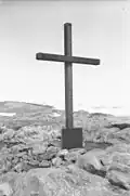 Kreuz und Gedenktafel am Kap Denison in George-V.-Land, errichtet von Douglas Mawson auf einem Hügel 300&nbsp;m südwestlich des Haupthauses der Australasiatischen Antarktisexpedition von 1911 bis 1914. Das Kreuz und die Gedenktafel erinnern an die Expeditionsteilnehmer Belgrave Ninnis und Xavier Mertz, die 1913 während der Expedition den Tod fanden.[Anm 1]