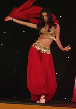 Tänzerin mit Schleier und Fransen- und Pailletten-besetztem Kostüm.