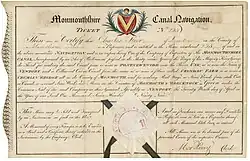 Aktie der Monmoutshire Canal Navigation, ausgegeben am 29. April 1799 in Stockton, mit Textauszug aus dem Act of Parliament von 1792, wonach die Gesellschaft das Recht hätte „rail ways“ und „stone roads“ zu bauen, um Hütten und Minen in der Region miteinander zu verbinden, was 1793 mit der Gründung der Trevil Tramroad Company als Untergesellschaft mit einem Kapital von 5.000 Pfund realisiert wurde. Die Pferdeeisenbahn wurde 1797 eröffnet.