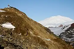 Gedenkkreuz für die Opfer des Flugzeugabsturzes von 1979 am Mount Erebus, Lewis-Bucht, Ross-Insel. Im Gedenken an die 257 Opfer verschiedener Nationalitäten, die ihr Leben verloren, als ihr Flugzeug an der Flanke des Mount Erebus zerschellte, wurde im Januar 1987 ein Kreuz aus Edelstahl auf einer Felsnase drei Kilometer von der Absturzstelle entfernt am Mount Erebus errichtet.