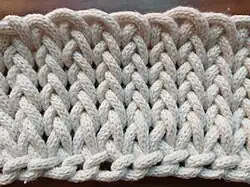 Auch die Vorderseite erinnert an glatt rechts Gestricktes. Jedoch wirken die vertikalen Strukturen wie geflochten.