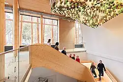 Eine Führungsgruppe geht eine Treppe hinunter und betrachtet das Licht-Kunstwerk an der Decke.