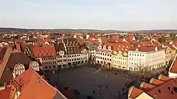 Von einer Drohne aufgenommen. Der Marktplatz ist quadratisch, an ihm stehen sanierte alte Patrizierhäuser mit roten Ziegeldächern und zahlreichen Dachgauben.