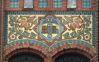 Über der Eingangsloggia rechts: Hermesstab als Symbol des Handels