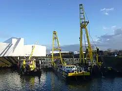 Nach Anbringen von Stahltrossen unter dem Rumpf der Pure-Liner 2 konnten die Schwimmkräne HEBO-Lift 6 und HEBO-Lift 7 den Havaristen gemeinsam anheben; links daneben das Mehrzweckschiff HEBO-Cat 15.