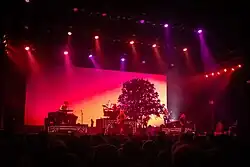 Dieses Bild zeigt die in roten Farbtönen illuminierte Bühne am Abend bei einem Konzert der Band Nightwish 2018 in Genf.