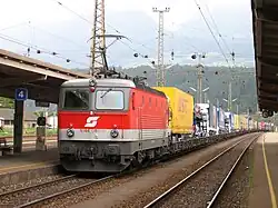Die 1044 060 der ÖBB als Schie­be­lok hin­ter einer „Rol­len­den Land­stra­ße“ im Bahnhof Spittal-Millstättersee