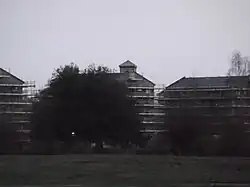 Blick auf die Neubauten der Studentenwohnheime von Port Meadow aus, dahinter ist die Kirche Sankt Barnabas in Oxford fast nicht mehr zu shene, nur der Turm ragt ein wenig über die Dächer hinaus.