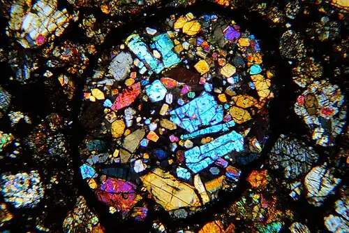 Porphyrisches Olivin-Chondron im Dünnschliff, gekreuzte Polarisatoren