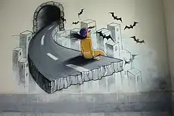 Aus einem Tunnel führt eine Straße die plötzlich abgerissen wird. Am abgerissenen Ende sitzt eine Frau in gelber Kleidung und mit dunklem, wehenden Haar. Im Hintergrund ist eine Stadtkulisse angedeutet und es flattern einige Fledermäuse um die Frau.