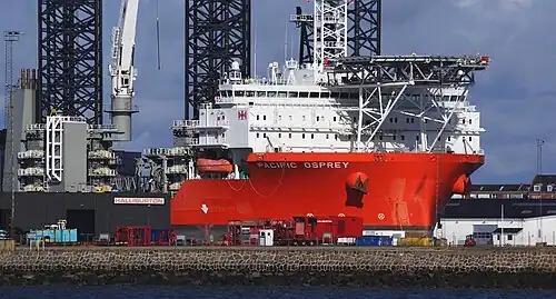 Errichterschiff Pacific Osprey mit Helikopter-Plattform vor der Schiffsbrücke