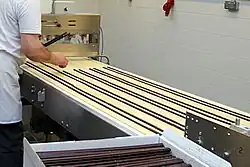 Belegen des ausgerollten Teigs mit Schokoladenstangen