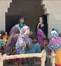 Dieses Bild zeigt eine Gruppe von Frauen und Kindern in einem ländlichen Umfeld.