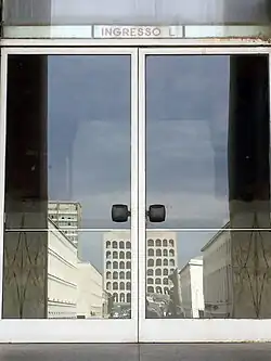 Eingangstür, in der sich der Palazzo della Civiltà Italiana spiegelt