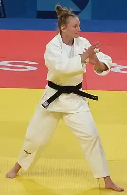 Pauline Starke im weißen Judogi steht in Kampfposition.