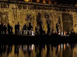 Bemalte Mauer mit riesigen Schatten am Ufer des Tiber, die die Siege und die Niederlagen der römischen Geschichte symbolisieren