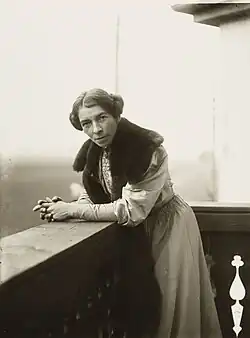 Anna Croissant-Rust auf einem Schwarzweißfoto von 1906, auf einem Balkon stehend