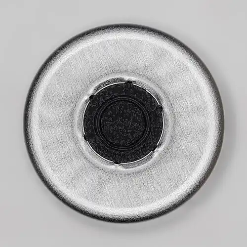 Phiole von oben mit aufgebrochenem Deckel für Impfstoff mit der zentralen Einstichfläche für die Spritze. Der Außendurchmesser des Deckels beträgt 14 Millimeter.