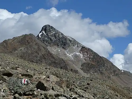 Piz Languard, aufgenommen von Costa dals Süts. Die Georgys Hütte befindet sich auf der obersten Terrasse am rechten Grat.