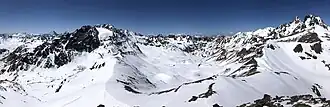 Blick vom Piz Faschalba auf den Grenzkamm: rechts der Verlauf über Bischofspitze, Kronenjoch, Krone und Fluchthorn, gerade nach hinten Futschölpass, Hängegletscher Vadret da Futschöl, Piz Blaisch Lunga (Augstenberg), mittig das Breite Futschöltal, links das Val Urschai