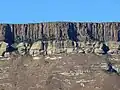 Steiler, vertikal gespaltener Drakensberg-Basalt, abgelagert auf der obersten Sandstein-Formation der Stormberg-Gruppe in der Provinz Freistaat