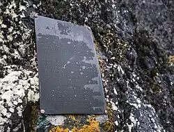 Erinnerungstafel aus Messing mit dem polnischen Adler, dem nationalen Wahrzeichen Polens, den Jahreszahlen 1975 und 1976 und folgendem Text auf Polnisch, Englisch und Russisch: „In Erinnerung an die Landung der Mitglieder der ersten polnischen maritimen Antarktis-Forschungsexpedition auf den Schiffen Profesor Siedlecki und Tazar im Februar 1976“. Diese Tafel befindet sich auf einer Seeklippe südwestlich der chilenischen und sowjetischen Stationen und ist der Maxwell Bay, Fildes-Halbinsel, King George Island zugewandt.