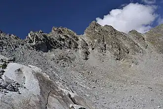 Polleskogel von Südosten; rechts der Mitte der Nördliche Polleskogel, links der Mitte der Südliche, dazwischen die Anstiegsrinne von Osten. Rechts zweigt der Polleskamm ab, links das Südliche Pollesjoch.