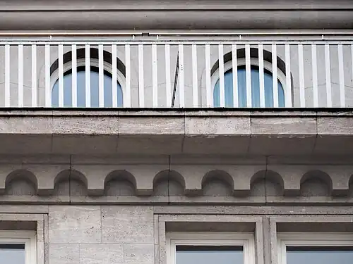 Detailfoto mit Reling, Rundbogenfries und den Faschen der Fenster.
