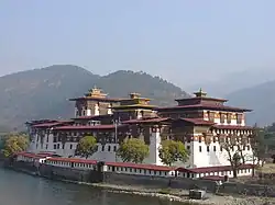 Punakha Dzong, Ansicht der Festung von außen mit dem Fluss Mo Chhu im Vordergrund.