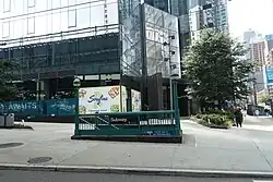 Eckeingangsgebäude zu 2&nbsp;und 3&nbsp;Jackson Park, davor ein Zugang zur Station „Queens Plaza“