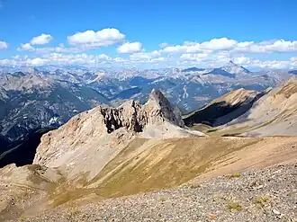 Blick auf größere Teile des Queyras von der Pointe de Rasis (2844&nbsp;m), Blick nach Nordwesten: Combe du Queyras (links im Mittelgrund, teilweise im Schatten), Col d’Izoard (rechts der Bildmitte, im Hintergrund), Pic de Rochebrune (höchster Gipfel rechts, im Hintergrund).
