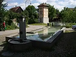 Dorfbrunnen von 1806 mit Transformatoren­häuschen