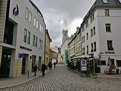 Menschen laufen auf einer Straße nahe des Markts in Weimar.