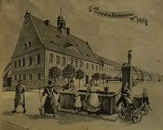 Das Kirchhainer Rathaus im Jahre 1905 mit dem städtischen Röhrbrunnen. Das Bild befindet sich im inneren des Rathauses als Wandbild.