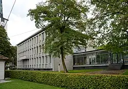 Foto des Rathauses zeigt einen schachtelförmigen Betonbau mit großen Fenstern auf den Längsseiten