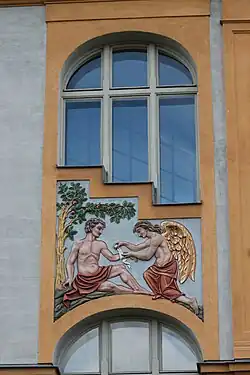 Unter einem Apfelbaum sitzender Mann mit rotem Schurz wird von einem vor ihm knieenden beflügelten Engel mit rotem Schurz am Arm verbunden