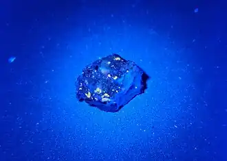 Fluoreszierender „Ribbeck“-Meteorit im UV-Licht mit λ = 365&nbsp;nm (Probe AKM03C)