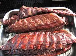 Babybackribs aus dem Barbecue-Smoker, zum Teil mit Barbecuesauce glasiert