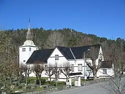 Foto einer Holzkirche mit Friedhof im Vordergrund