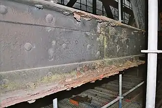 Ein stark angerosteter Träger einer genieteten Stahlbrücke