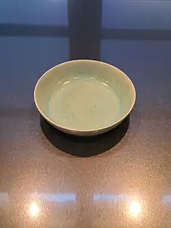 Eine dezent grün-blau schimmernde flache Keramikschale