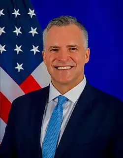 Portraitfoto eines Mannes vor einer US-amerikanischen Flagge