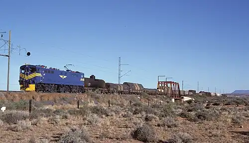 E7008 im blauen Spezialanstrich der SAR für den Einsatz vor dem Blue Train, aber vor einem Güterzug bei Die Put, ungefähr 16&nbsp;km südlich von De Aar, eingesetzt, am 2. Mai 1985