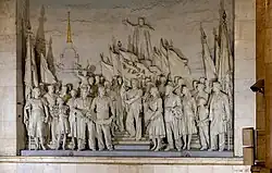 Narwskaja, Sankt Petersburg (1955): Die Bevölkerung vereint unter Lenin, Geschichte/Tradition und Zukunft/Aufbau verbunden; die Fahne im Zentrum trägt das Schlagwort Слава Труду (Slawa Trudu, dt. Ruhm (gelte) der Arbeit)