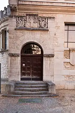 Rundbogenportal mit der Inschrift Ehrenhalle Friedrich Ludwig Jahn, darüber das von Arabesken gerahmtes Turnerkreuz