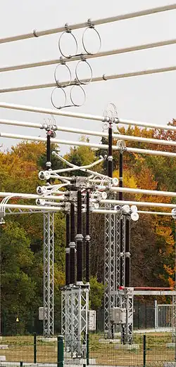 Eine Gruppe von drei Trennern (Bauart Pantograf- oder Scherentrenner, geöffnet) in einer Freiluftschaltanlage für 380&nbsp;kV