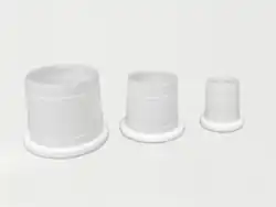 Drei weiße konische Kunststoffhülsen auf einem Hellen Untergrund. Der breitere Rand ist verstärkt der schmalere läuft sehr dünn aus.